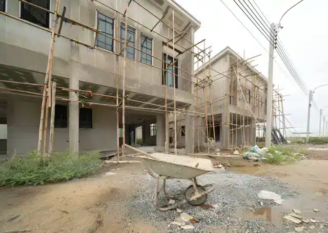 Unfinished apartment building in Nigeria with scaffolding and cranes